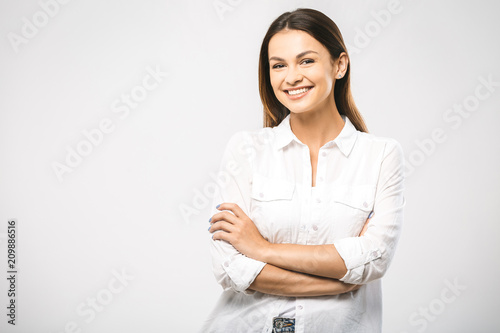 Portrait of happy smiling young beautiful woman, isolated over white background. Looking at camera. Free space for text.