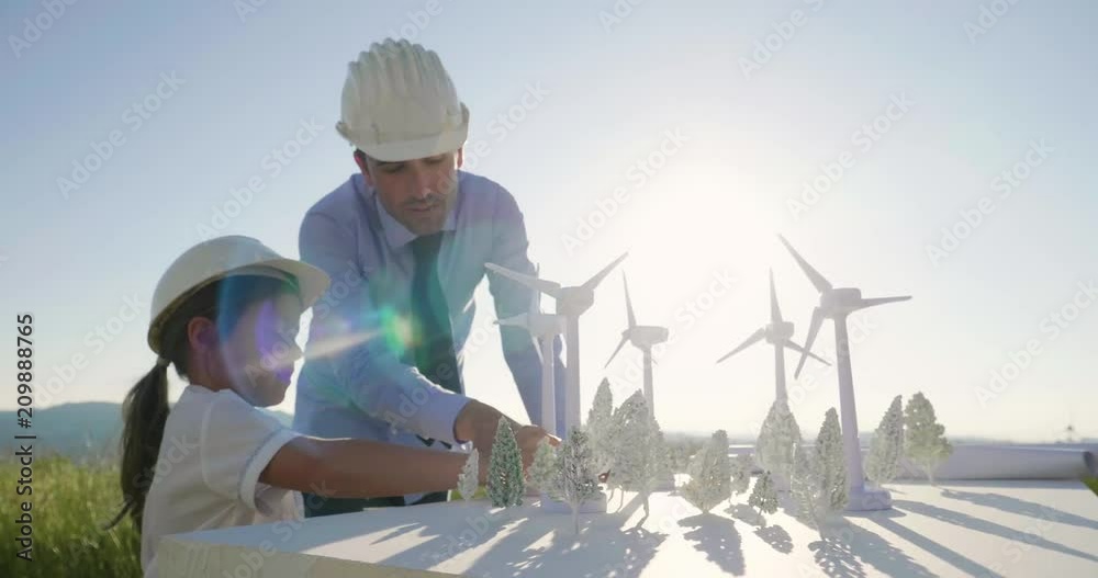 A father engineer shows his project to his daughter for the construction of a wind farm. The daughter is interested in renewable energy. Concept of: family, engineering, future love for nature.