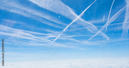 Multiple contrails cross paths through the sky photo