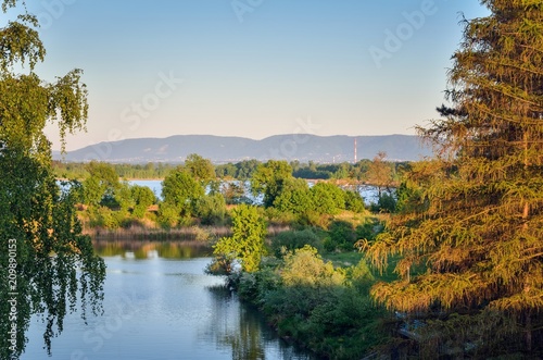 Spring evening landscape. Beautiful lakes and mountains in the background.