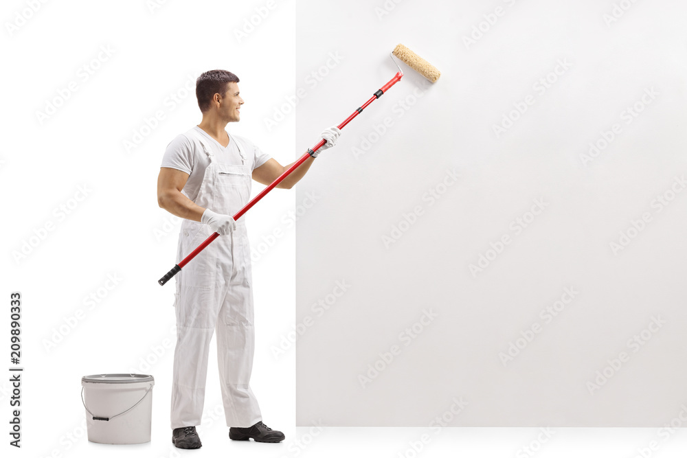 Painter painting a wall with a paint roller Painter painting a wall with a paint roller