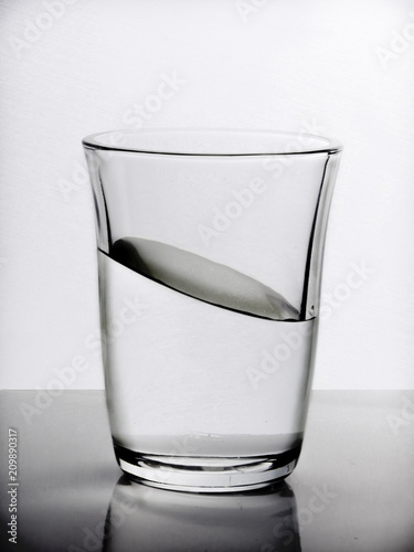 Creative still life with water tilted in a glass