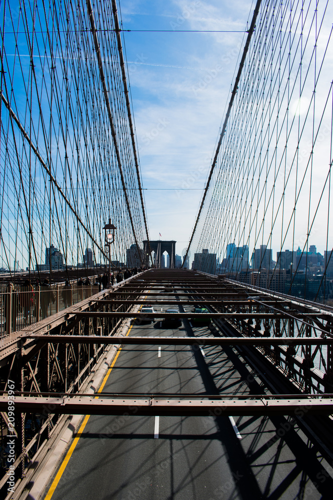 Fototapeta premium Brooklyn bridge over water, blue sky with sunshine