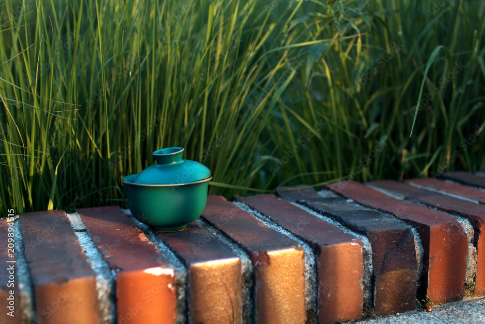Naklejka premium tea with Orange slice in a traditional Japanese cup or bowl with a lid