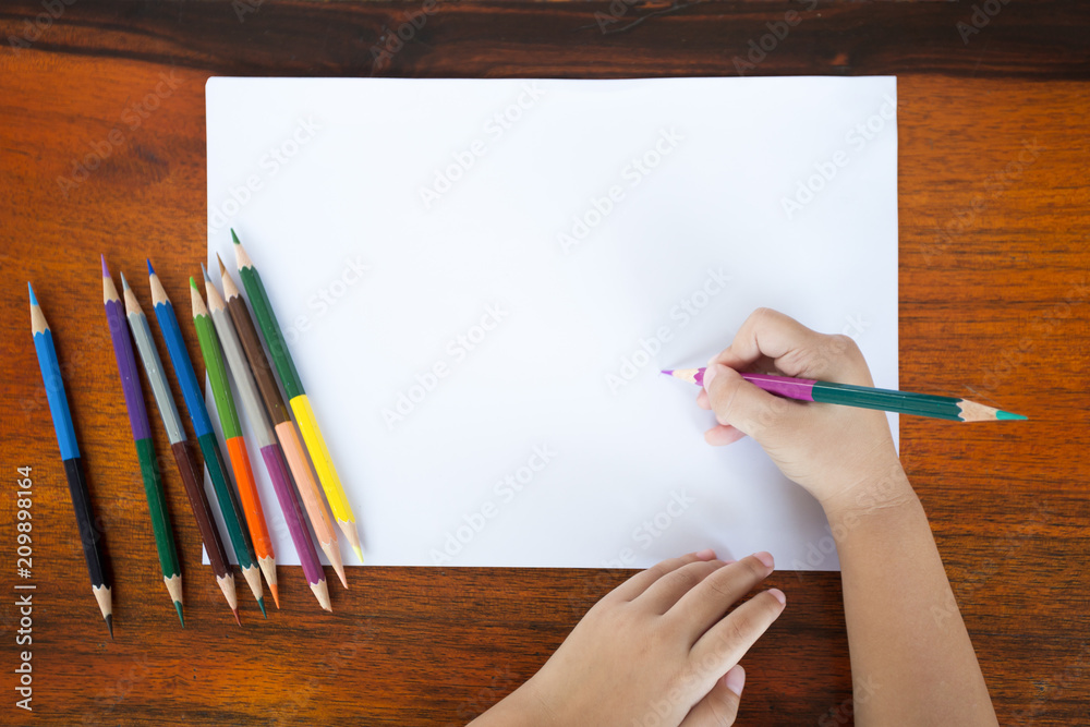 Asian little boy use color pencil writing on white paper Asian little boy use color pencil writing on white paper
