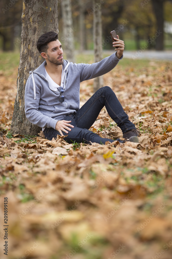 Handsome man in nature reading a book. Autumn leaves. Copy space Handsome man in nature reading a book. Autumn leaves. Copy space
