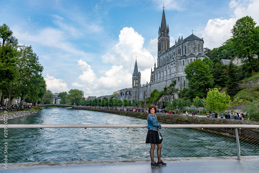 Woman in front of pilgrimage church in Lourdes