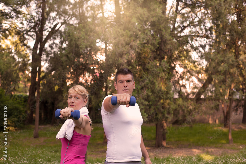 Obraz premium Couple exercising with dumbbells .