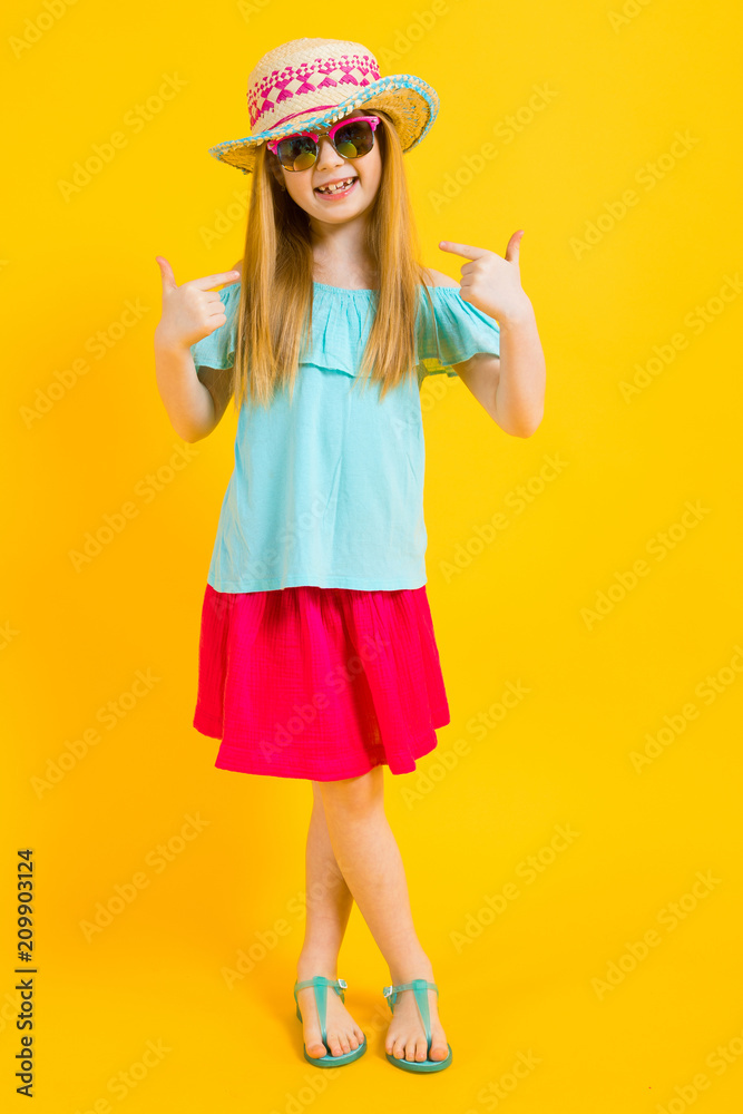 Girl with red hair on a yellow background. Charming girl in bright summer clothes shows fingers on herself. Girl with red hair on a yellow background. Charming girl in bright summer clothes shows fingers on herself.