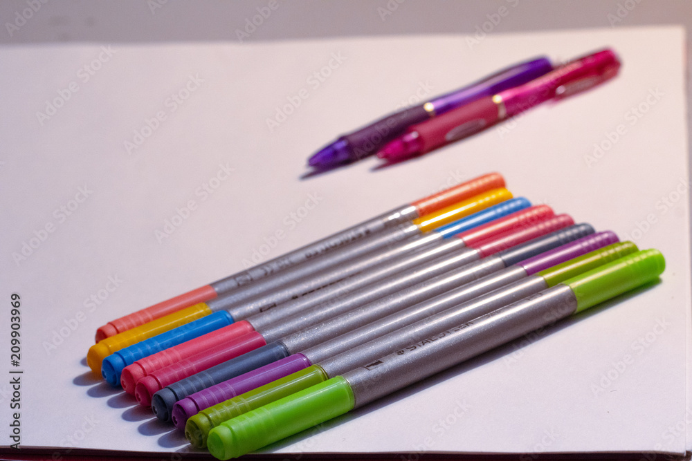Fototapeta premium A variety of colored markers against white paper 