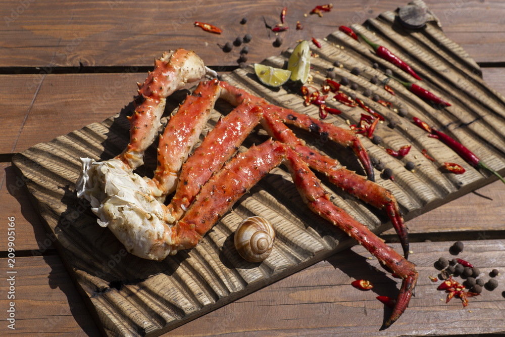 Fresh crab claws with sauce, pepper and lemon on vintage wooden background.
Fresh crab claws with sauce, pepper and lemon on vintage wooden background.