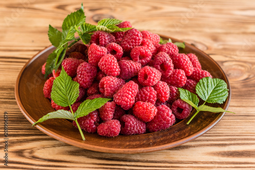Tasty juicy sweet raspberry on a wooden background. It can be used as a background
