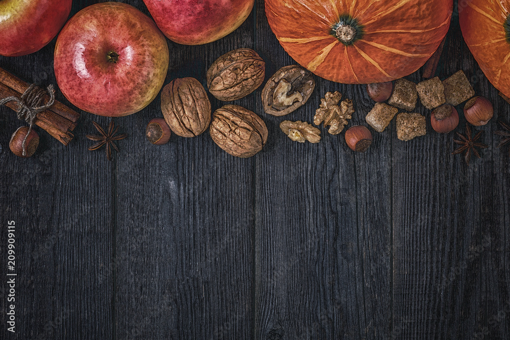 Wooden background with pumpkin, apples, nuts and spices. Wooden background with pumpkin, apples, nuts and spices.