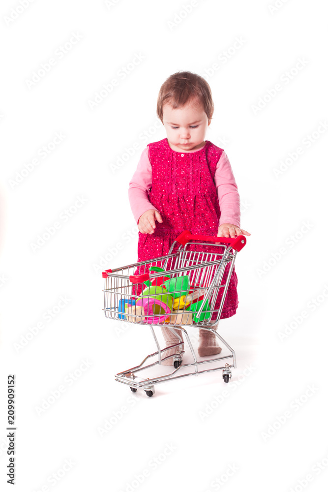 Cute baby girl playing with toy shopping cart. Cute baby girl playing with toy shopping cart.