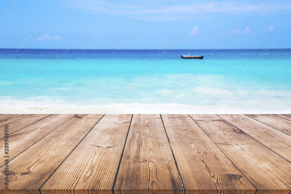 Fototapeta premium Wood table with blue sea and sand beach background 