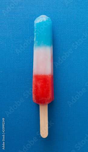 Red White and Blue Popsicle on a Blue Background photo