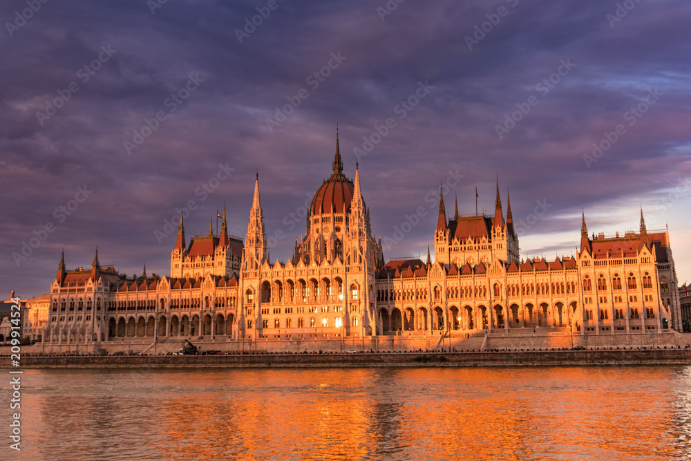 Hungarian parliament building in Budapest at sunset, view from the Danube river Hungarian parliament building in Budapest at sunset, view from the Danube river