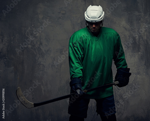Photography Professional hockey player trains in full equipment with gaming stick against a gray background