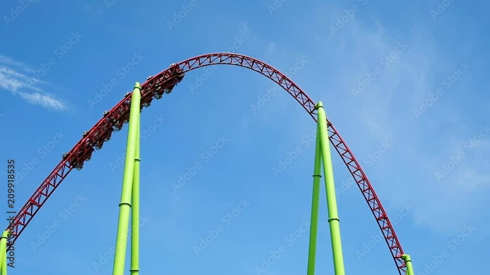 Attraction roller coasters against the blue sky, slow motion Attraction roller coasters against the blue sky, slow motion