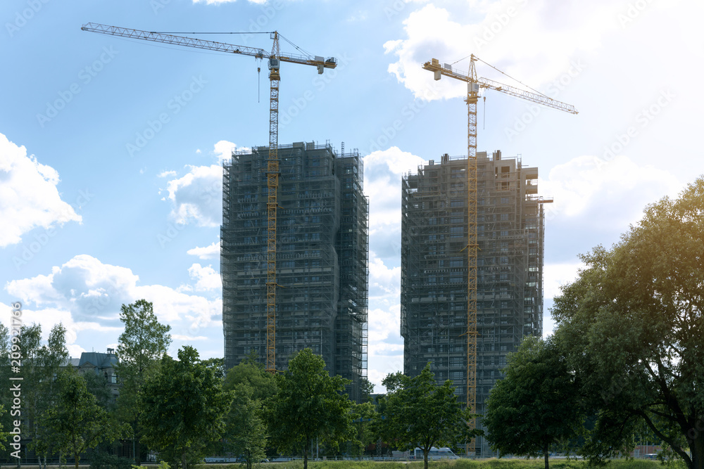 Modern architecture. Construction of skyscraper. Construction site with cranes Modern architecture. Construction of skyscraper. Construction site with cranes