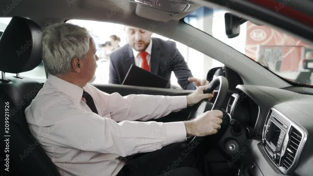 Test drive. Client at the steering wheel. The sales man is outside. Client closeup. Test drive. Client at the steering wheel. The sales man is outside. Client closeup.