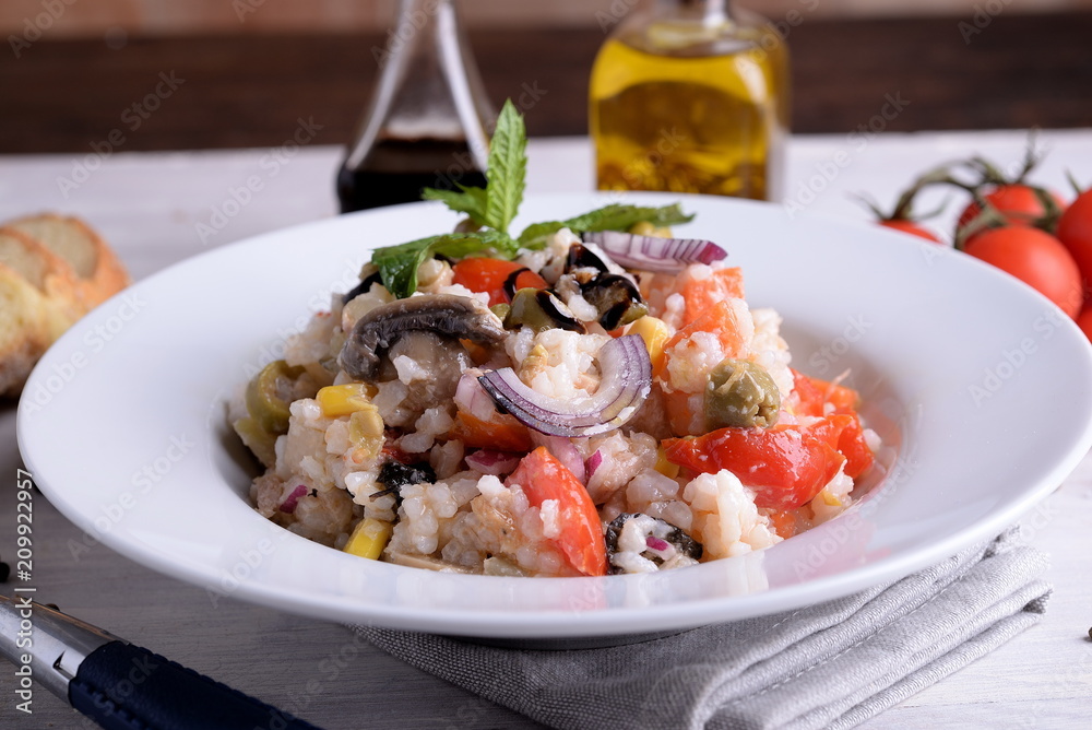 Rice salad with vegetables on white plate 
 