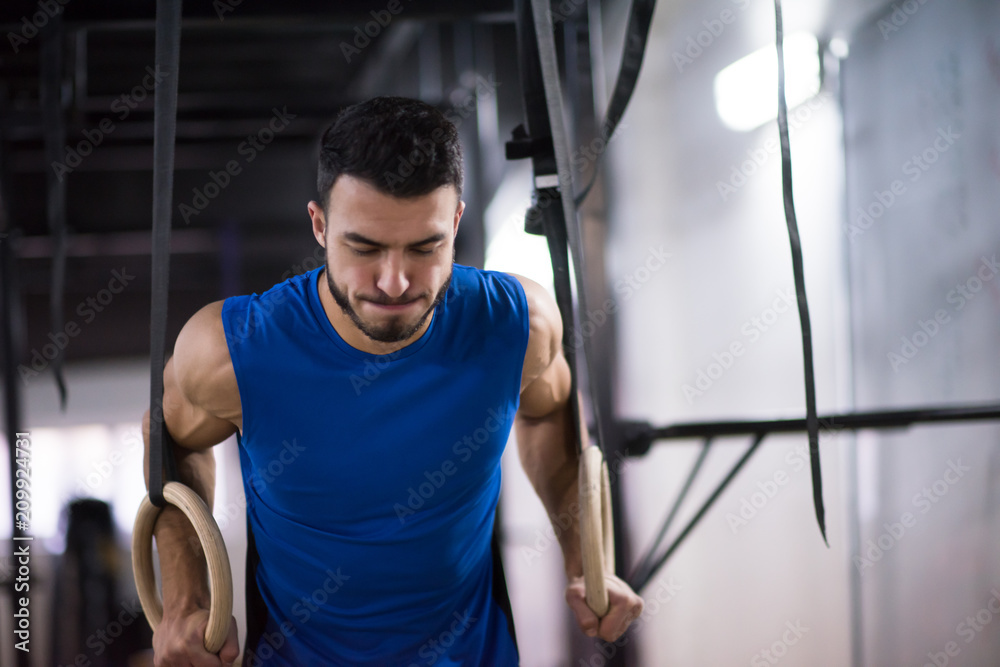 man working out pull ups with gymnastic rings man working out pull ups with gymnastic rings