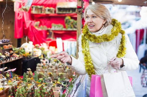 Smiling woman is buying Christmas ornamentals in the market