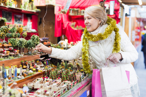 Mature woman choosing decorations at Christmas market