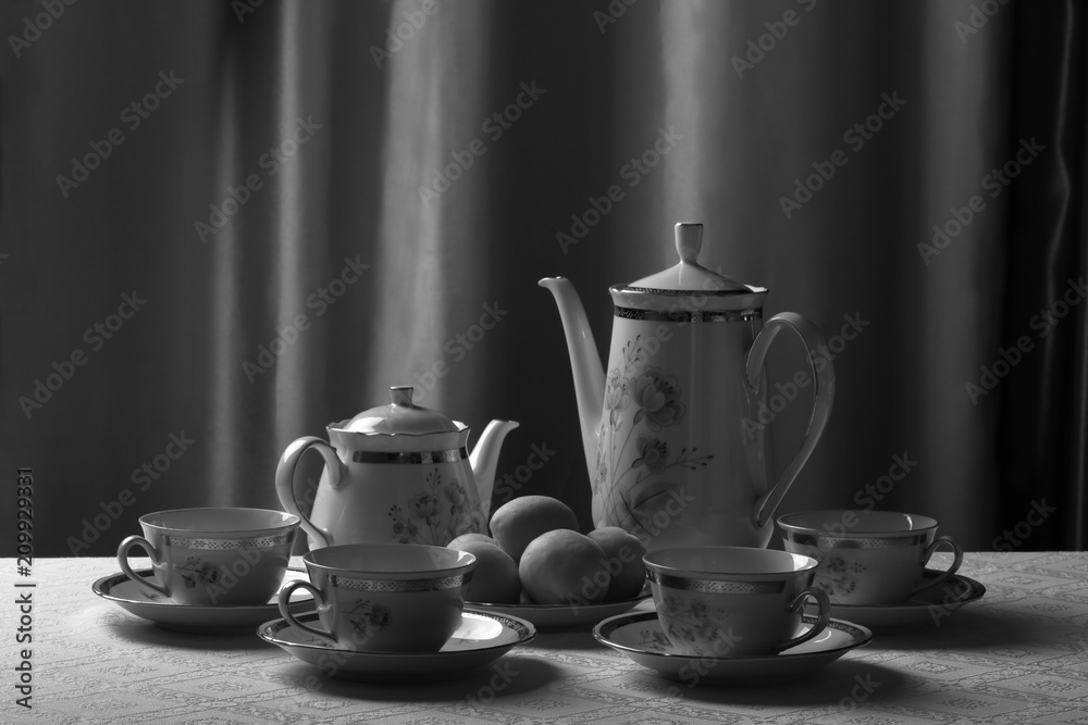 Porcelain tea set with a pattern in the form of flowers on a white tablecloth Porcelain tea set with a pattern in the form of flowers on a white tablecloth