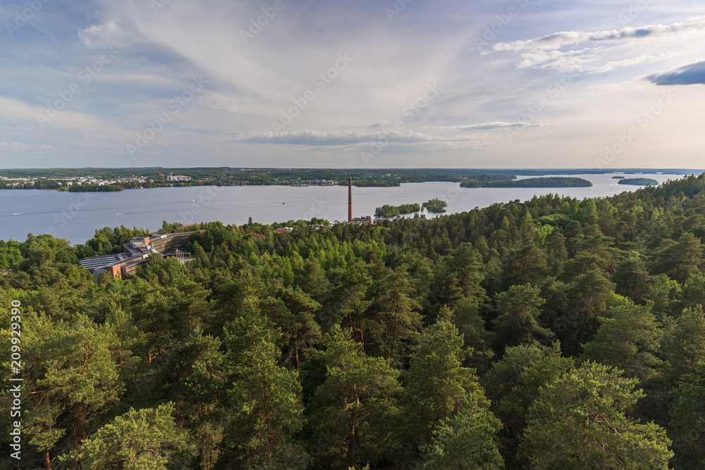 Buildings, forest at the Pyynikki ridge, Lake Pyhäjärvi and beyond in Tampere, Finland, viewed from above on a sunny day in the summer.