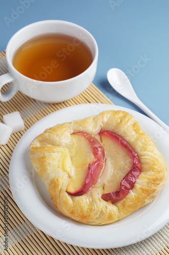 Bun with apples and cup of tea