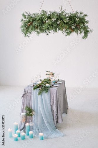 Wedding. Banquet. The chairs and table for guests, decorated with candles, served with cutlery and crockery and covered with a tablecloth. photo