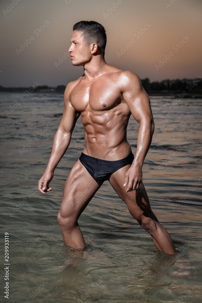 Muscular young sexy wet boy in a underwear posing in the sea at sunset  Stock Photo | Adobe Stock
