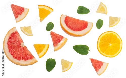 Sliced pieces of citrus fruits isolated on white  top view