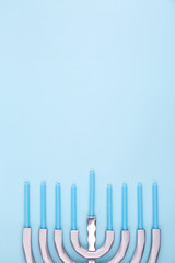 Blue background with menora and candles. Hanukkah and judaic holiday concept.
