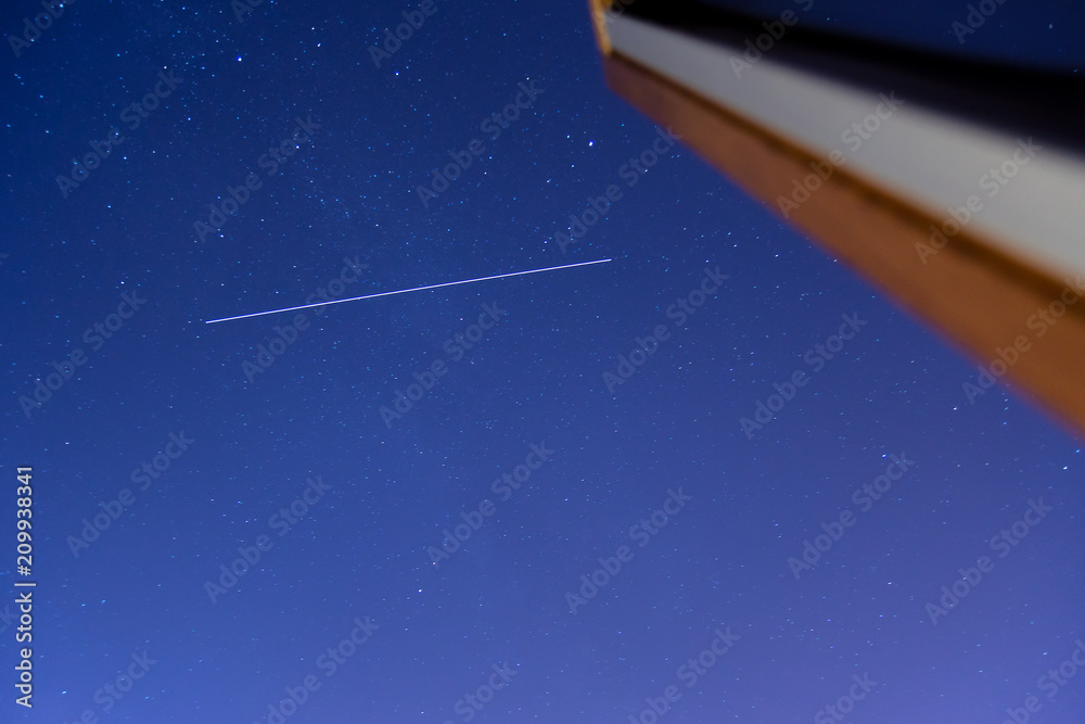 International Space Station ISS trail crossing sky with stars as seen from roof window International Space Station ISS trail crossing sky with stars as seen from roof window