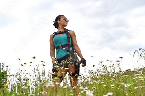 A young girl gets dressed up as a cosplay action girl. She poses outdoors and makes good attempts  at acting the part of a super hero fantasy figure. photo