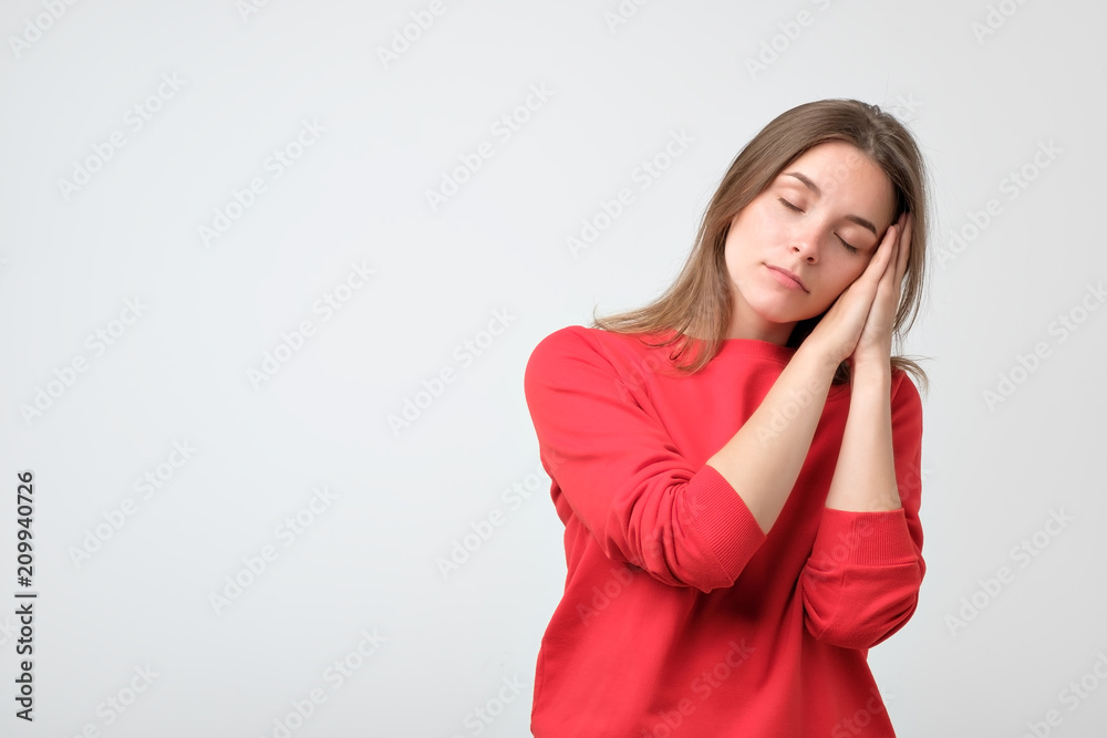 Young caucasian woman in red clothes wanting to sleep. She has no energy Young caucasian woman in red clothes wanting to sleep. She has no energy
