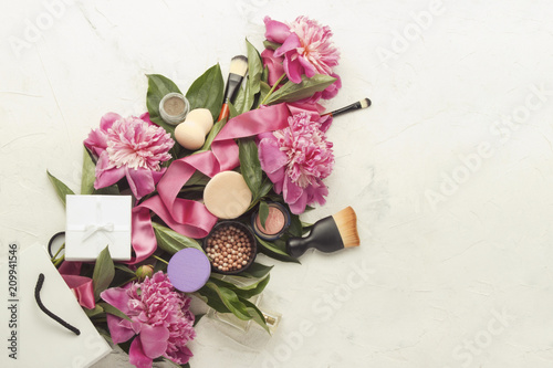 Gift package, decorative cosmetics, pink peonies and a gift box on a light background. Top view.