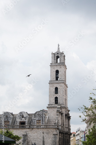 Pigeon flies near the belfry of the Basilica de San Francisco de Asís (Basilica of San Francisco of Asis) in the Plaza of San Francisco, also known as Pigeon Square, in Old Town Havana, Cuba.