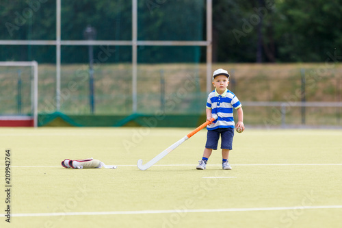 Small funny boy playing field hockey with stick. Concept field hockey image with copy space