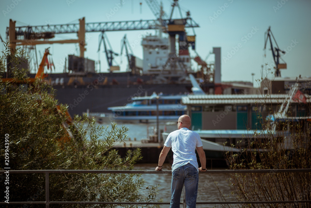 Mann lässt den Blick über Schiffe wandern