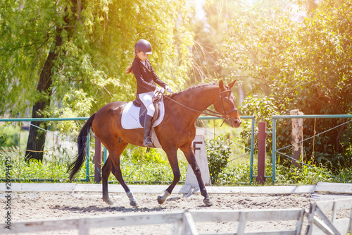 Young girl riding horse on equestrian competition. Equestrian dressage sport background with copy space