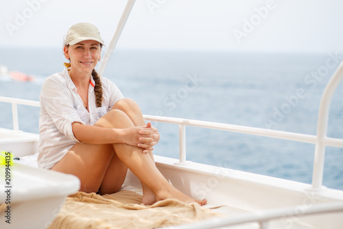 Young woman enjoying summer vacation on sea. Happy girl on yacht cruise. Image with copy space © skumer
