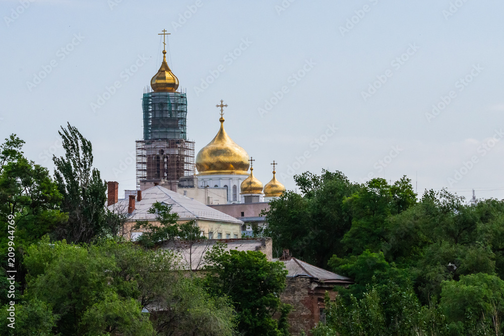 White Orthodox Church with big golden domes on a sunny day