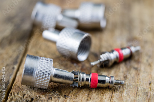 Inner tube valve on a wooden workshop table. Accessories for vulcanizer for repairing inner tubes and car tires. photo