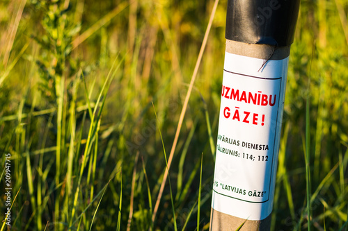 Obraz na plátně Gas caution pole in latvian
