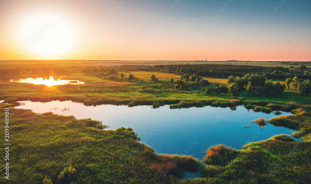 Aerial view above summer forest and lake at sunset, beautiful nature landscape panorama