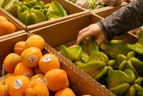 Bilde på lerret Motion of woman's hand picking starfruit inside Superstore